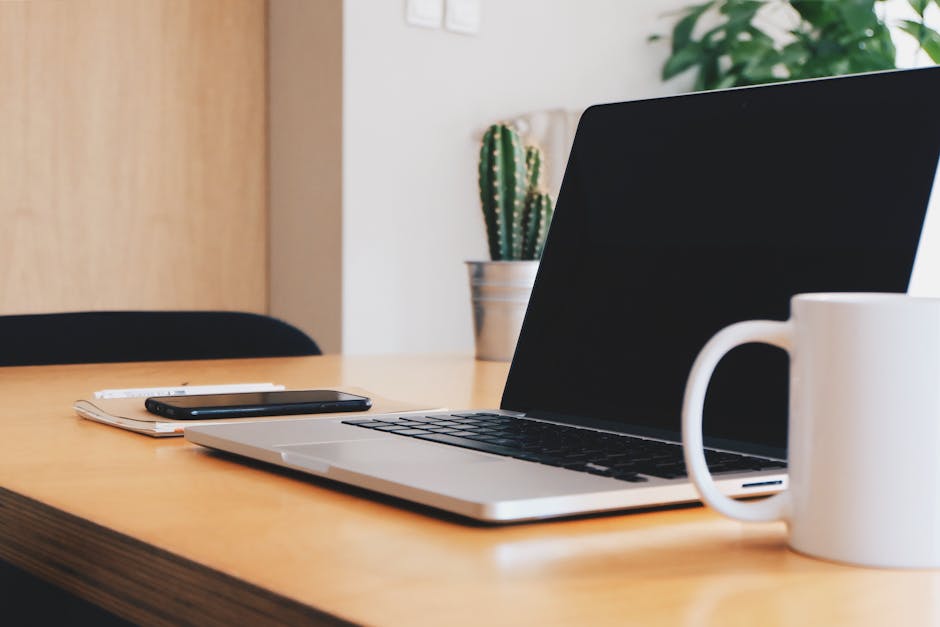 Macbook Pro on Tabletop Beside Mug